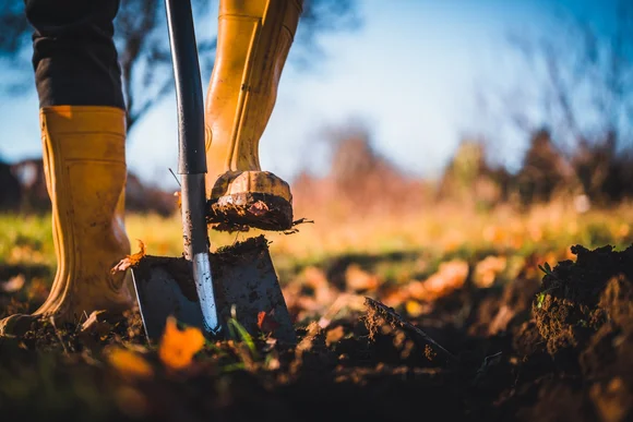 Person mit Schaufel im Garten